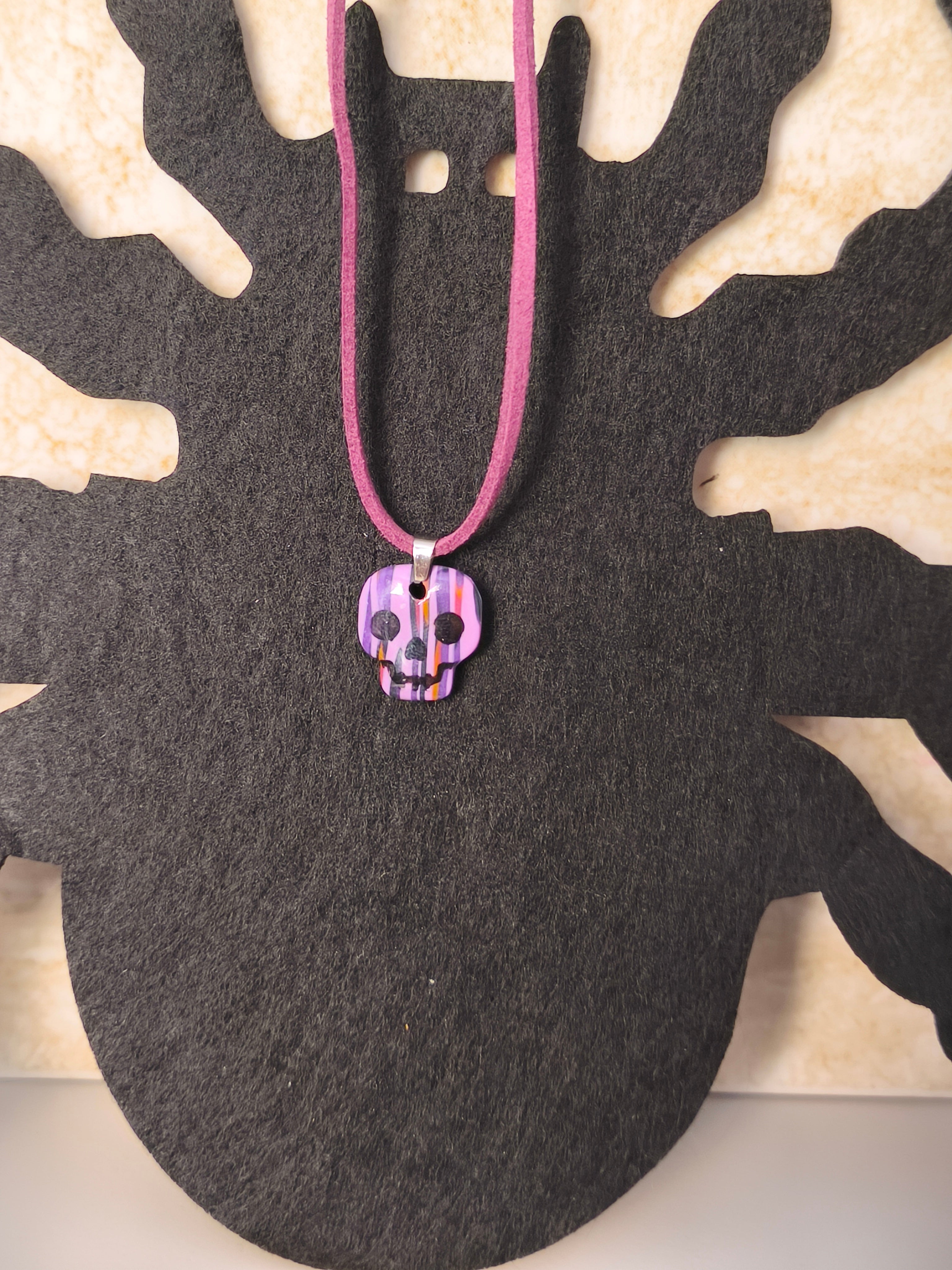 Colgante calavera morado, negro, rosa y naranja