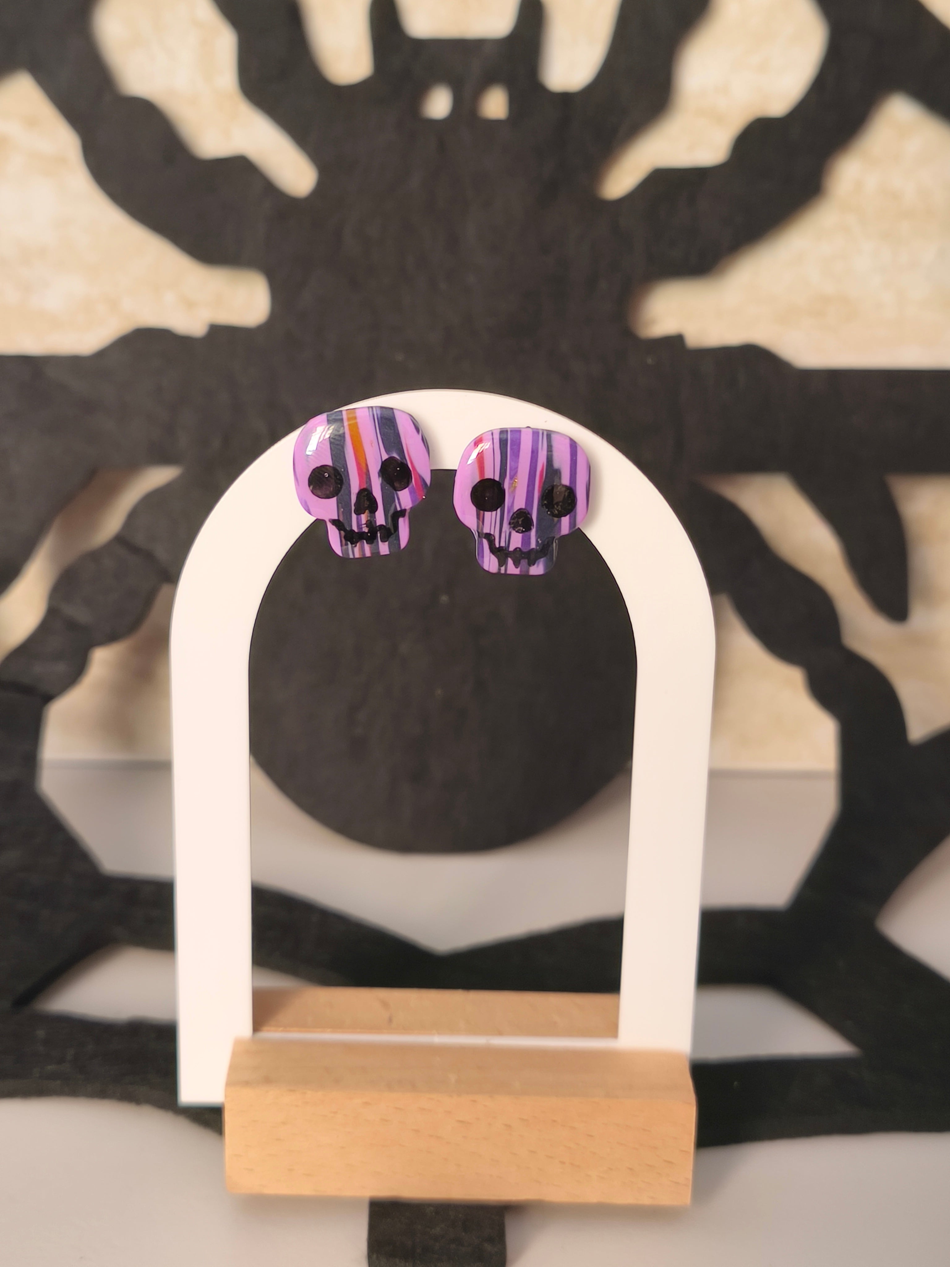 Calaveras morado, rosa, negro y naranja